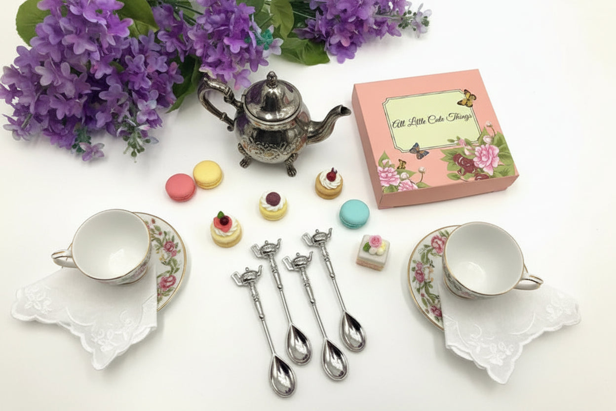 Set of decorative spoons with a decorative box and purple flowers on a white background