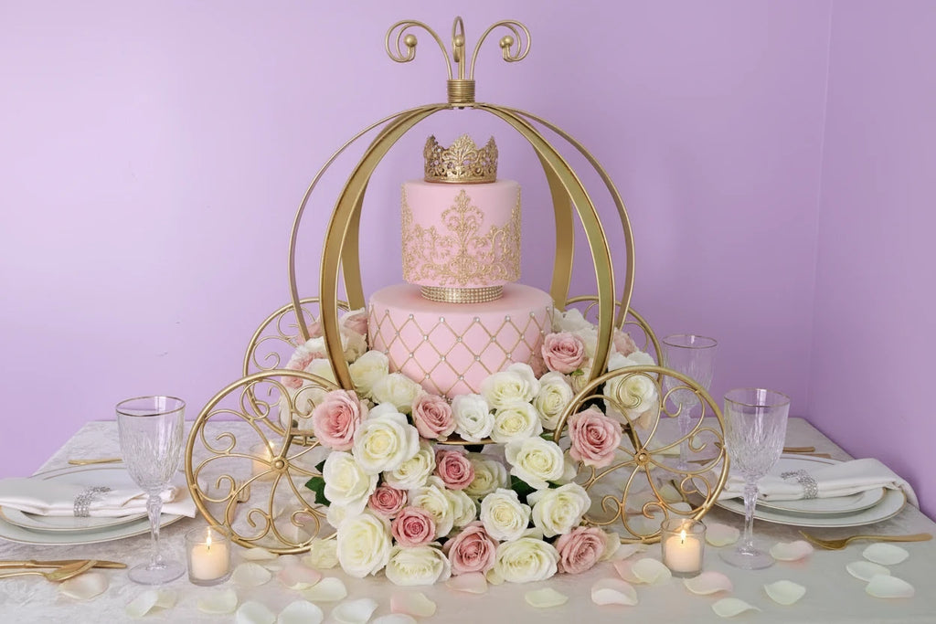 White cake with gold crown on a decorative gold carriage against a light blue background