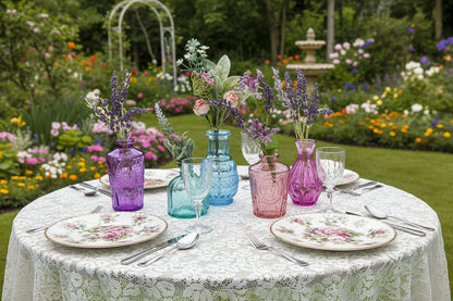 Set of colorful glass vases with flowers on a white background